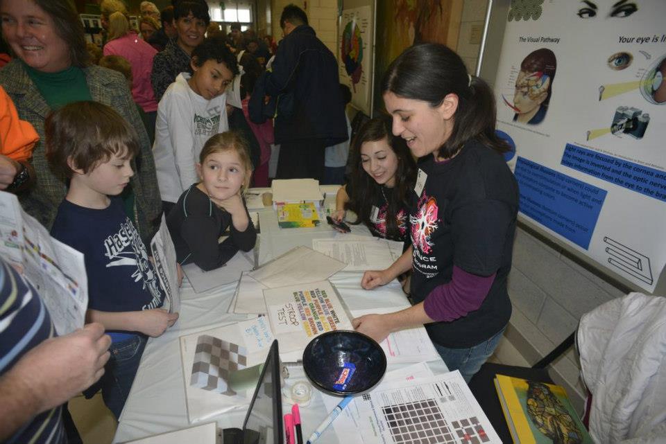 Christina Ragan challenging attendees with optical illusions at a previous Brain Awareness Day Neuroscience event held at Michigan State University.